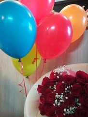 Helium balloons with bouquet of red roses
